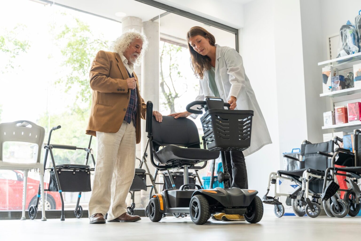 Older man trying out electric mobility scooter in shop