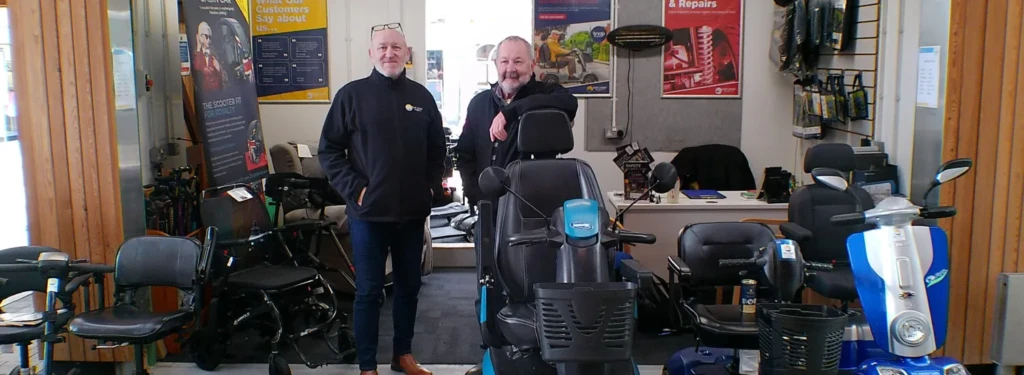 Inside of East Coast Mobility shop with two employees standing next to mobility scooters